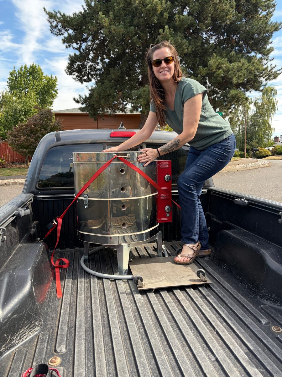 Christine steadying a kiln strapped into the back of a pickup truck